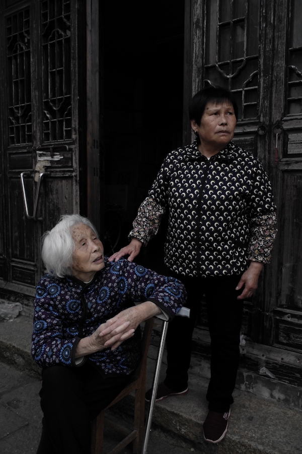 新场古镇内坐在街边的90岁阿婆