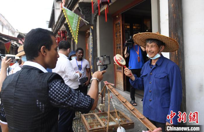 来自孟加拉国的方舟(左)在拍摄义乌货担郎零售。　王刚 摄
