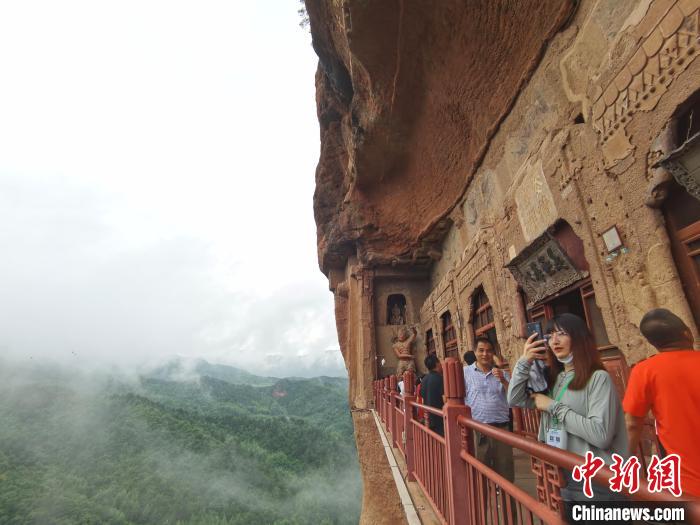 图为游人拍摄麦积山石窟风景区“仙境”。　张婧 摄