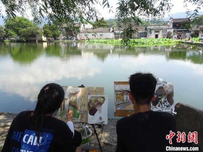 大批写生游客围坐在黟县宏村景区南湖畔写生绘画。 吴寿宜 摄 大批写生游客围坐在黟县宏村景区南湖畔写生绘画。 吴寿宜 摄