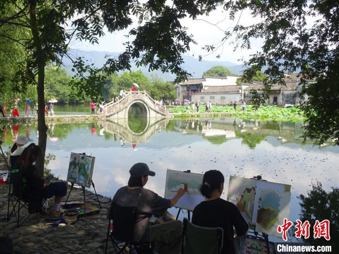 大批写生游客围坐在黟县宏村景区南湖畔写生绘画。 吴寿宜 摄 大批写生游客围坐在黟县宏村景区南湖畔写生绘画。 吴寿宜 摄