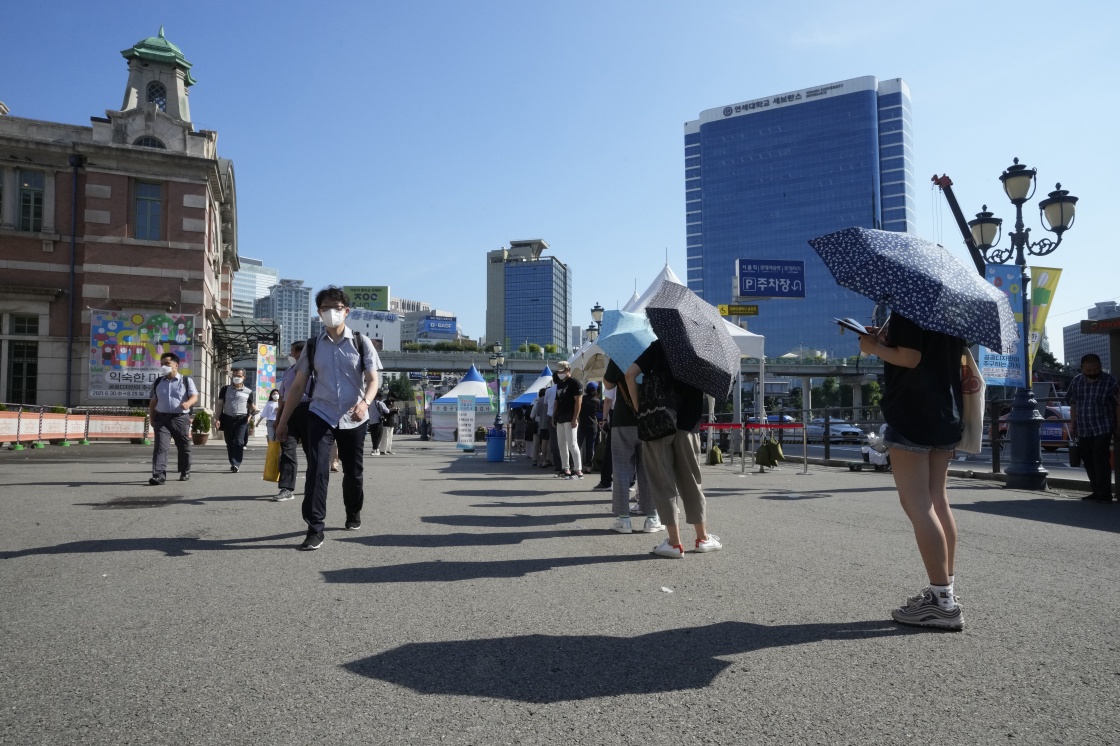 7月21日，人们在韩国首尔一处核酸检测点排队等待接受核酸检测。新华社 图
