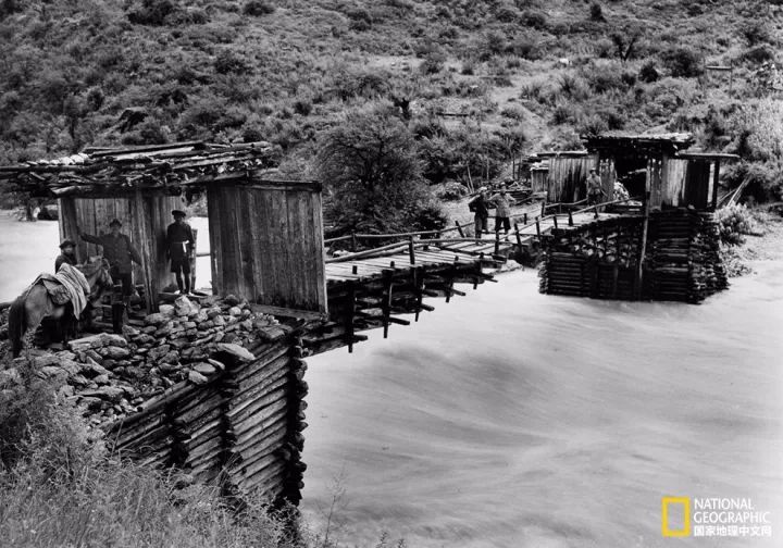 1928年，洛克和探险队成员通过一座悬臂桥横渡急湍的理塘河 供图：NAT GEO COLLECTION