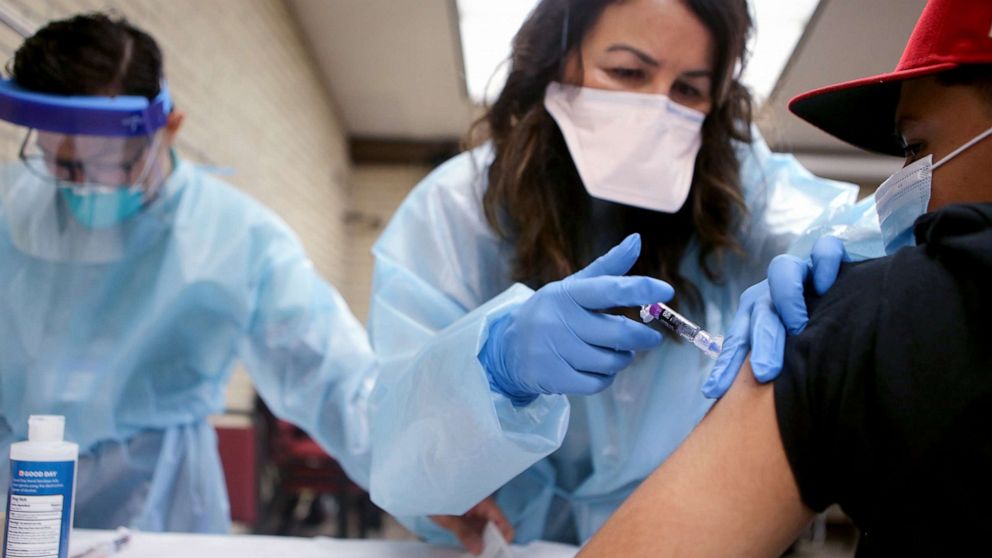 PHOTO: In this Oct. 14, 2020, file photo, a nurse gives a flu vaccination shot to a young man at a free clinic held at a local library in Lakewood, Calif.