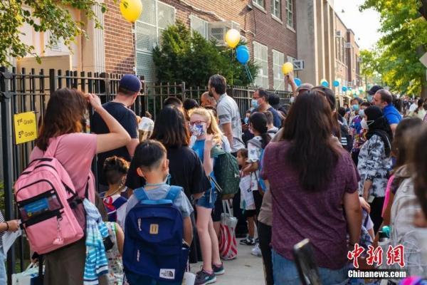 当地时间9月13日,美国纽约市公立学校开学,皇后区一所公立学校门前学生排队进入学校。开学后,纽约市公立学校不再提供线上课程。<a target='_blank' data-cke-saved-href='http://www.chinanews.com/' href='http://www.chinanews.com/'>中新社</a>记者 廖攀 摄 点击进入下一页