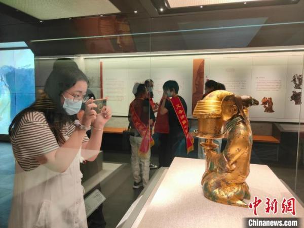图为一名观众观赏长信宫灯。 杨大勇 摄 图为一名观众观赏长信宫灯。 杨大勇 摄