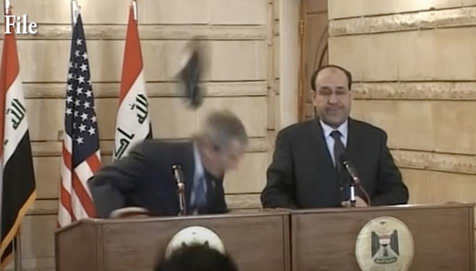 2008年，伊拉克记者扎伊迪向小布什扔鞋，小布什躲闪的瞬间。