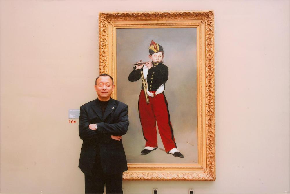李向阳与“法国印象派绘画珍品展”展出的马奈画作《吹短笛的男孩》，2004年