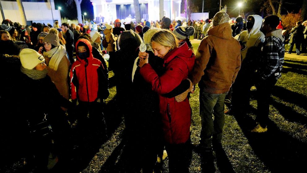 PHOTO: Maddi Maederer, 18 hugs another community member during a candle light vigil in Cutler Park after a car plowed through a holiday parade in Waukesha, Wis., Nov. 22, 2021. 
