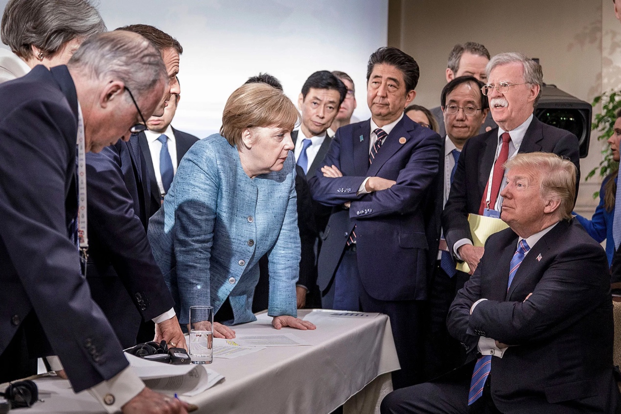 2018年G7峰会，默克尔俯身盯着特朗普，英国广播公司对此刊文称默克尔的举动“就像一名严厉的教师要责骂一名坏学生”。