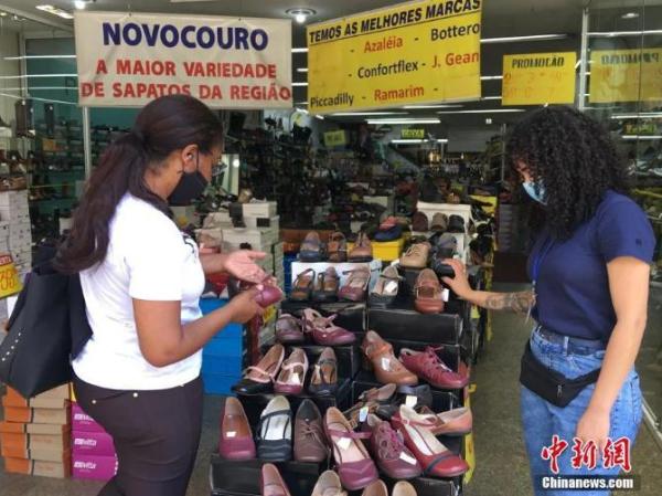 当地时间11月16日，巴西圣保罗，顾客在一商场内购买鞋子。圣保罗市市长里卡多·努内斯(Ricardo Nunes)日前宣布，根据当前新冠疫情的态势及评估，该市决定维持目前实施的在公共场所强制民众佩戴口罩的防疫措施，预计该措施将持续到12月初。<a target='_blank'  data-cke-saved-href='http://www.chinanews.com/' href='http://www.chinanews.com/'>中新社</a>记者 莫成雄 摄