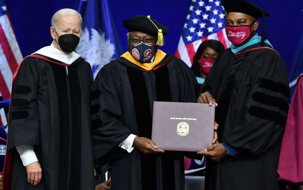 PHOTO: Rep. Jim Clyburn, center, with President Joe Biden, receives his history diploma during a commencement ceremony at South Carolina State University in Orangeburg, S.C., Dec. 17, 2021.