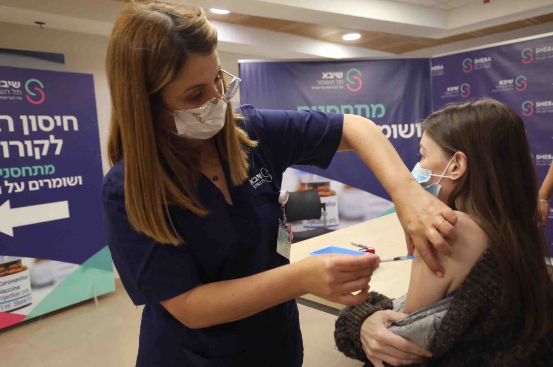 一名女子在以色列拉马特甘的谢巴医疗中心接种第四剂新冠疫苗。新华社 图