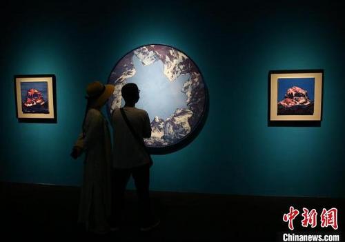 中国侨网1月28日，主题为“合颂”的唐卡非遗艺术展在三亚南山非遗中心展出。图为游客在参观唐卡展。　陈文武 摄