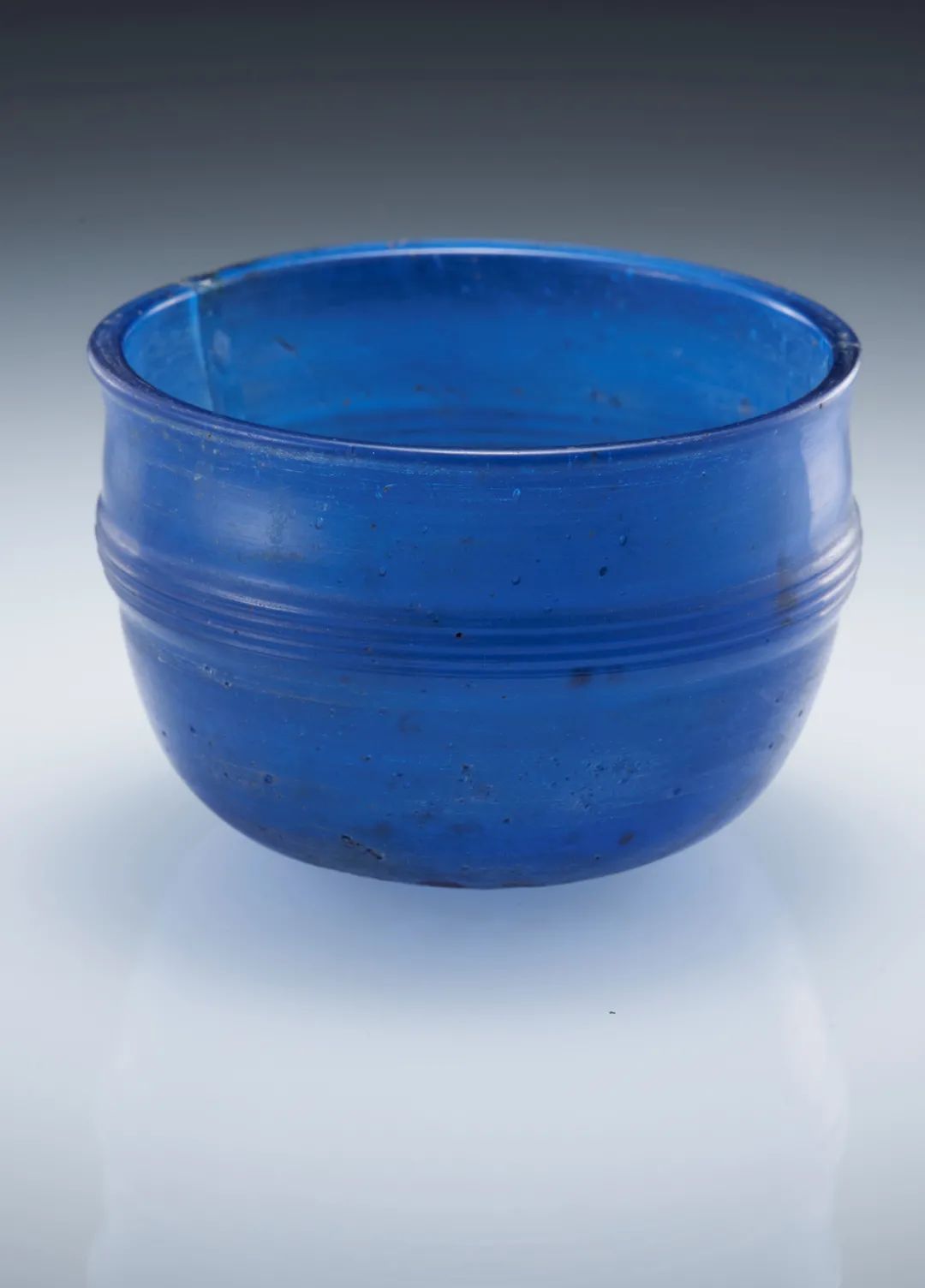 蓝色弦纹玻璃杯，西汉，公元前202- 公元 8 年，广西贵港深钉岭（孔圣岭）12 号墓出土，广西壮族自治区博物馆藏