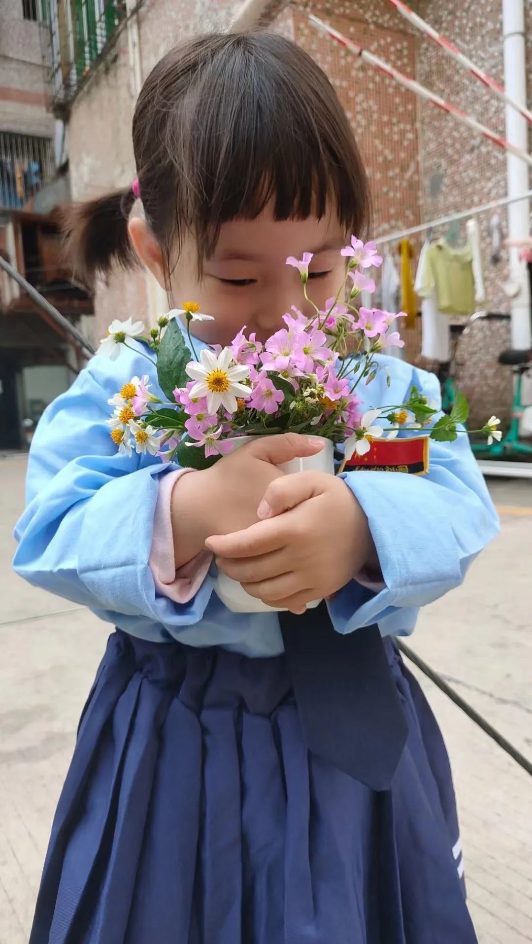 ▲ 范明月女儿抱着摘来的野花。图 / 受访者提供