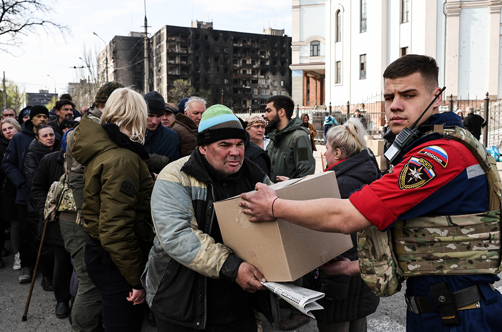 当地时间2022年4月19日，乌克兰马里乌波尔，士兵们在街道上分发人道主义救援物资。   澎湃影像 图
