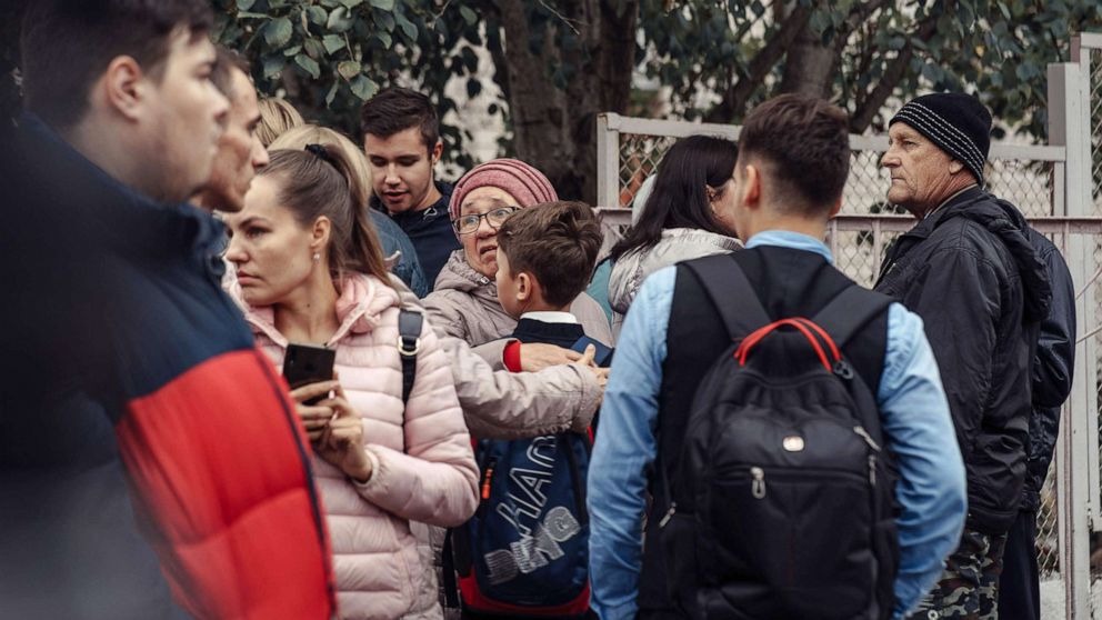 PHOTO: A woman hugs a boy surrounded by other people near the scene of a shooting at a school in Izhevsk, Russia, Sept. 26, 2022.