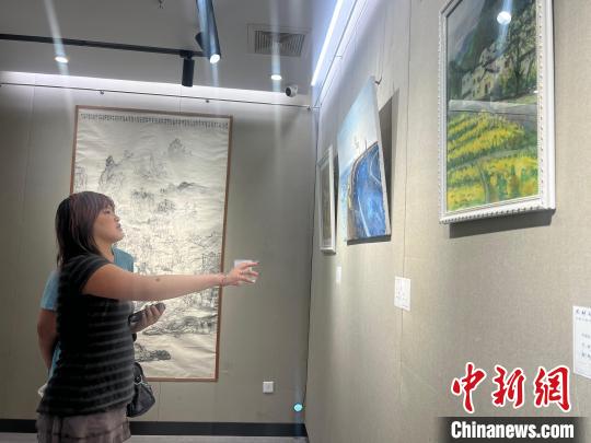合肥市青年美术大展启幕,美国华裔青年画家把蔓沁正在参观作品。 储玮玮 摄 合肥市青年美术大展启幕,美国华裔青年画家把蔓沁正在参观作品。 储玮玮 摄