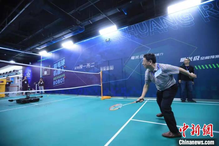 海外华文媒体代表体验与羽毛球机器人“对战”。　王磊 摄