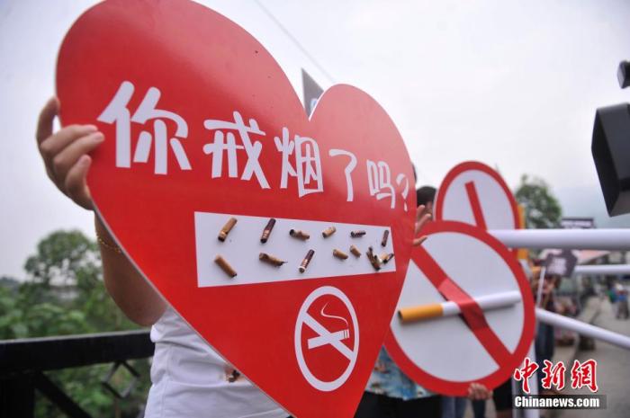 5月30日,重庆涪陵红酒小镇景区的工作人员拿着写有“你戒烟了吗”桃心形状牌要求游客灭掉手中的香烟,迎世界无烟日。陈超 摄 5月30日,重庆涪陵红酒小镇景区的工作人员拿着写有“你戒烟了吗”桃心形状牌要求游客灭掉手中的香烟,迎世界无烟日。陈超 摄